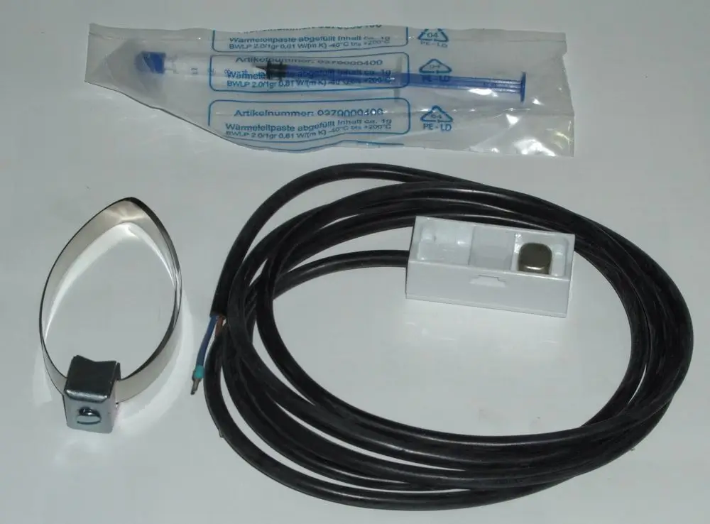 Daikin Mischerkreisfühler-Zubehör bestehend aus einem Sensor mit Kabel und Anschlussstück sowie einer Tube Wärmeleitpaste, auf einem weißen Hintergrund.